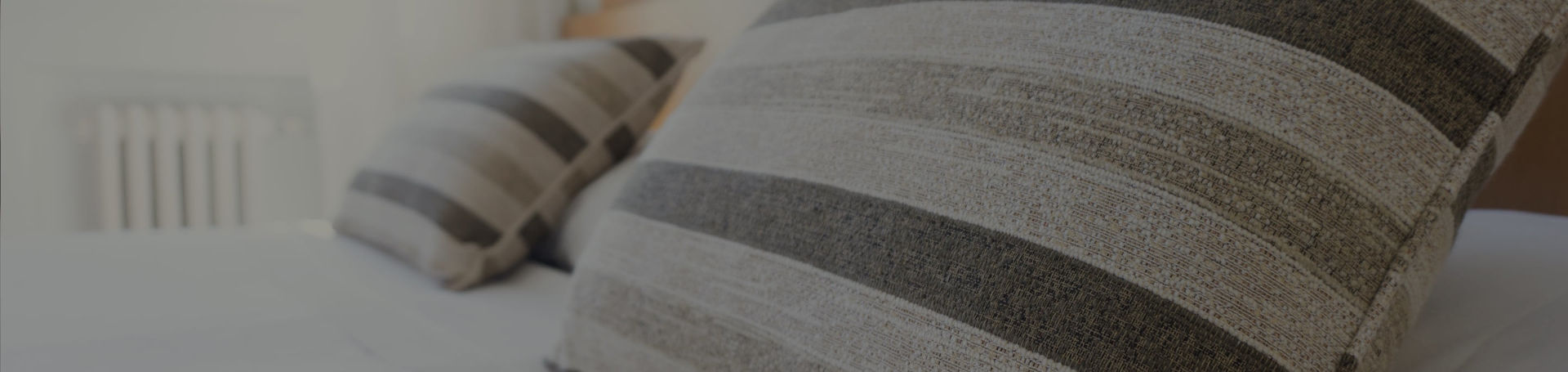 Dos cojines con un estampado estriado sobre una cama de matrimonio