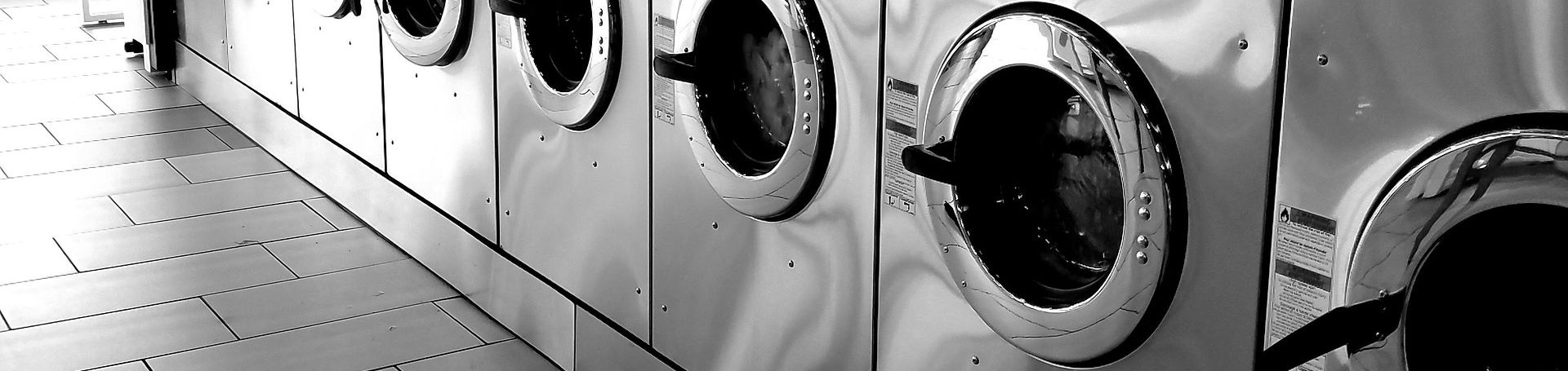 Una fila de lavadoras con superficie metálica, listas para empezar a funcionar