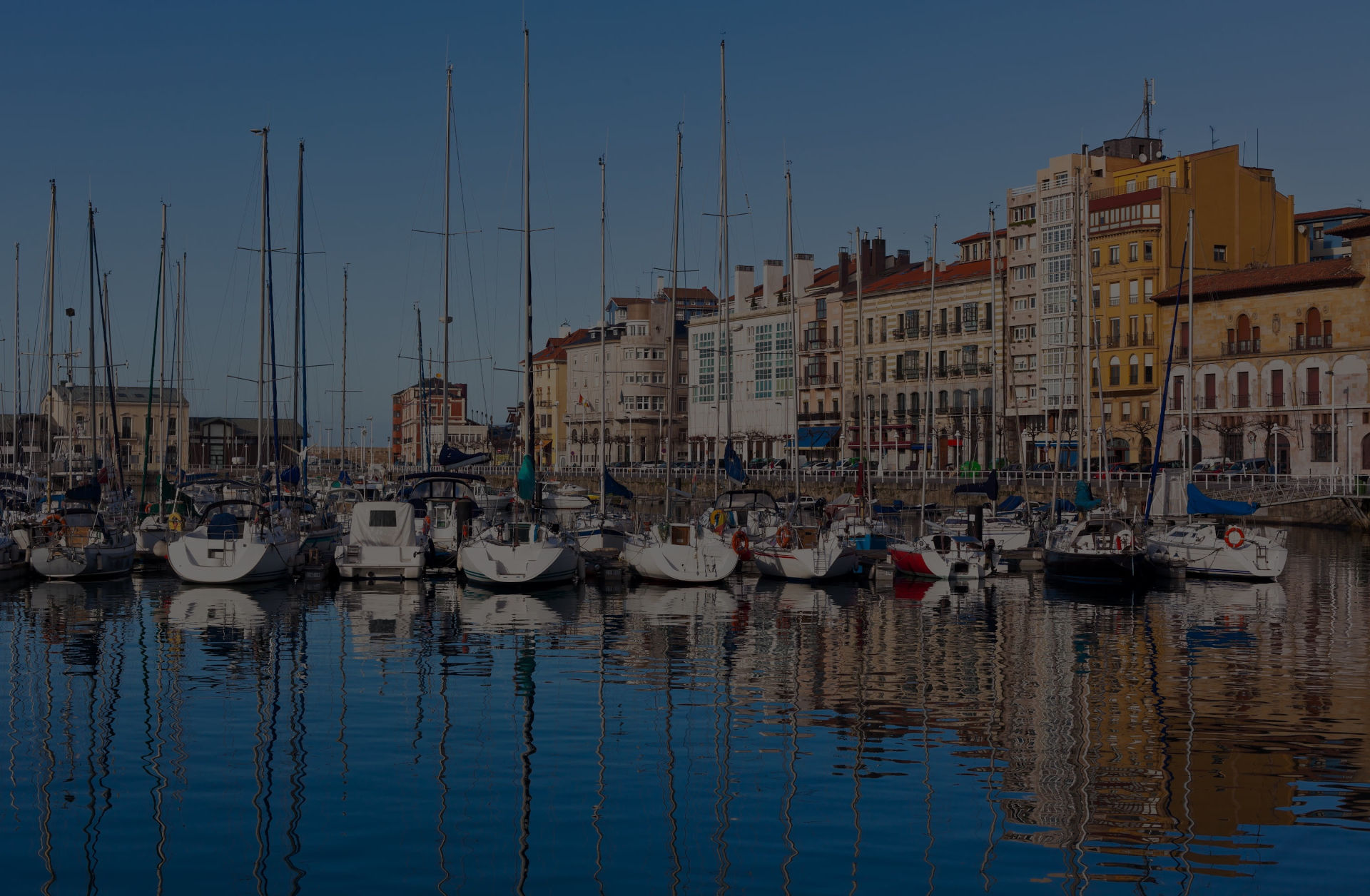 El puerto deportivo de Gijón, con los barcos amarrados contra los edificios de Gijón