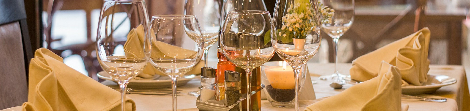 Una mesa de restaurante preparada para cuatro comensales, con toda la cubertería disponible